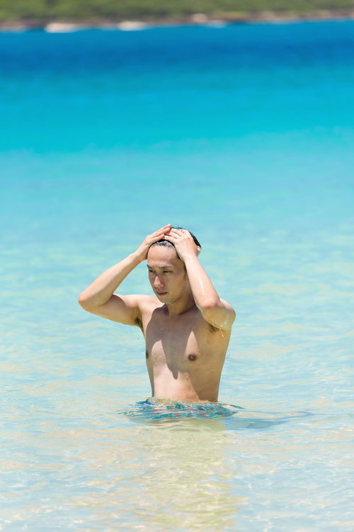 透き通る海に入るイケメンボーイ