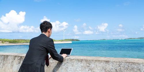防波堤にMacBook Airを置き、打ち合わせをするノマドファイター