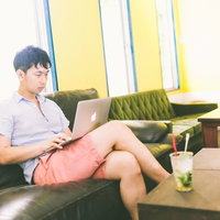 コワーキングカフェで動画コンテンツを真剣に試聴する男性の写真
