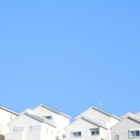澄んだ青空に映える丘の上の住宅群と広がる新築住宅地の風景の写真
