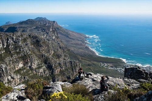 テーブルマウンテンから続く広大な海を撮影する観光客