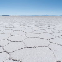 乾季のウユニ塩湖の広大な塩原と遠方の山々の写真
