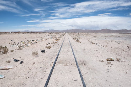 ボリビアのウユニ市にある列車の墓場の線路両脇にポイ捨てされたゴミの写真