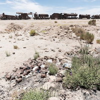 ウユニ市の列車の墓場に散在するごみと廃棄物の写真