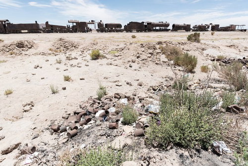 ウユニ市の列車の墓場に散在するごみと廃棄物の写真