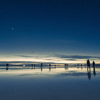 観光客で溢れるウユニ塩湖の星空と夜明けの絶景の写真