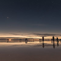 ウユニ塩湖の日没から夜明けへ、星空を眺める観光客たちの写真
