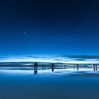 日が暮れたウユニ塩湖と人々のシルエットの写真