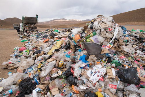 ゴミ収集車と積み重なる大量の廃棄物（ウユニ市）の写真