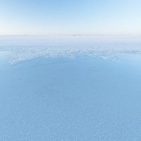 ウユニ塩湖の雨季に映る空と島影、鏡のような水面風景の写真