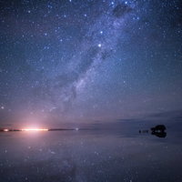 星空が湖面に反射するウユニ塩湖の雨季の夜景の写真