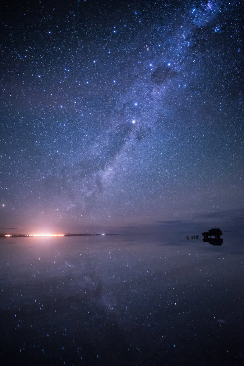星空と銀河が水面に反射するウユニ塩湖の雨季の夜景