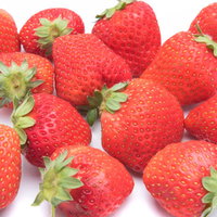 不揃いの赤い苺、白背景に散らばる新鮮なフルーツの写真