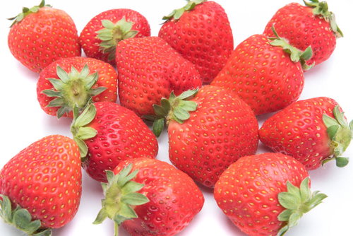 不揃いの赤い苺、白背景に散らばる新鮮なフルーツ