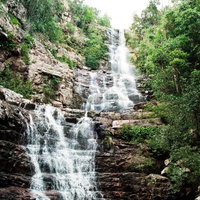 段に分かれ落ちる滝と岩肌、水しぶきが舞う渓谷風景の写真