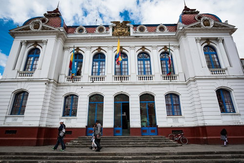 コロンビアの役場の前を歩く通行人たちと白い建築物