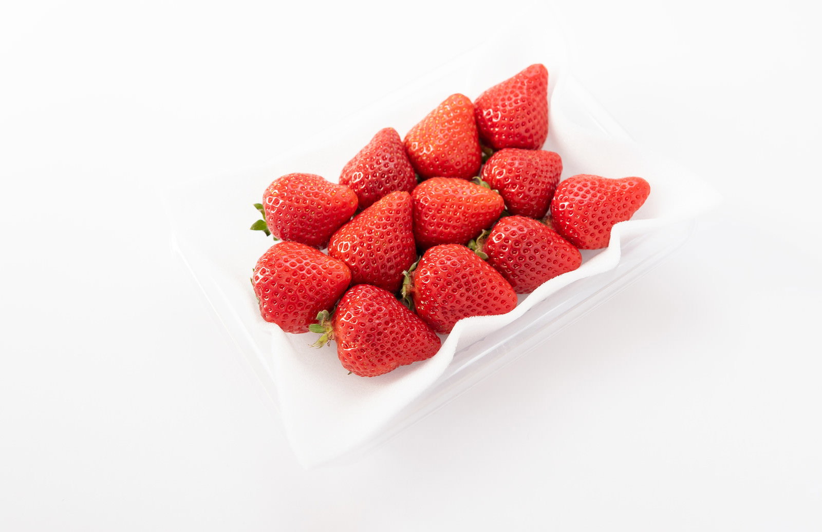 透明なプラスチックパックに入った赤いいちごが整列している