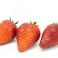 果皮が傷んだ3つのいちご、白背景に並ぶ生鮮食品の品質管理イメージの写真