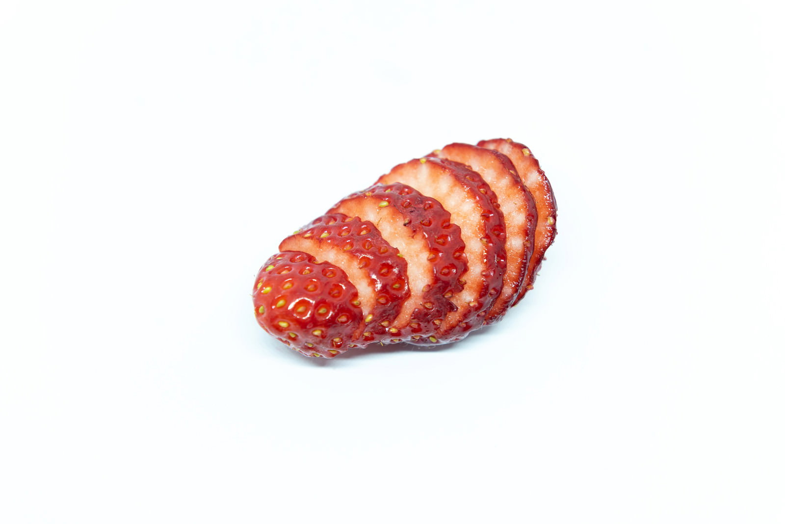 白い背景にスライスされた赤いいちごが並んでいる