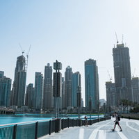 超高層ビル群へと続くドバイの水辺の道路と都市風景の写真