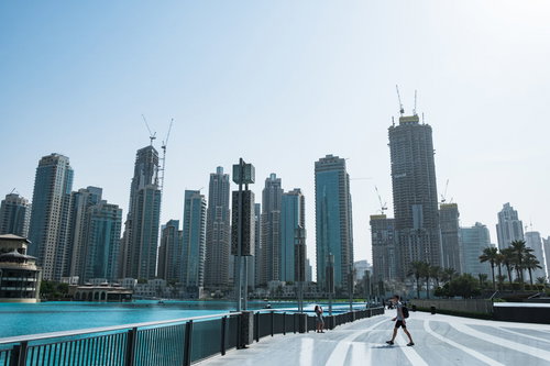 超高層ビル群へと続くドバイの水辺の道路と都市風景