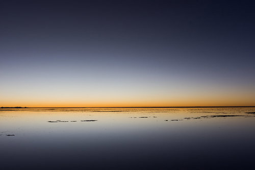 ウユニ塩湖の日没時の地平線に映る夕焼けの風景