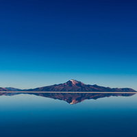 雨季の鏡張りになったウユニ塩湖に映る山と絶景の写真