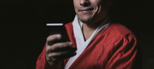 スマホでサンタコスイベント情報を検索する男性