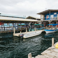 青い海に停泊するボートと海上の家（パナマ）の写真