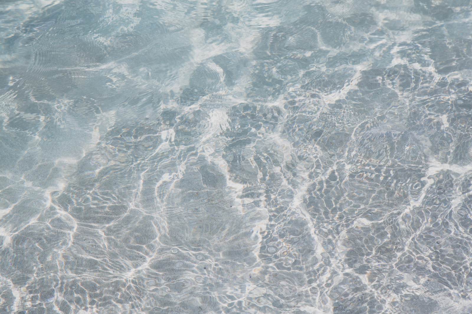 太陽光が反射する透明な浅い海の水面