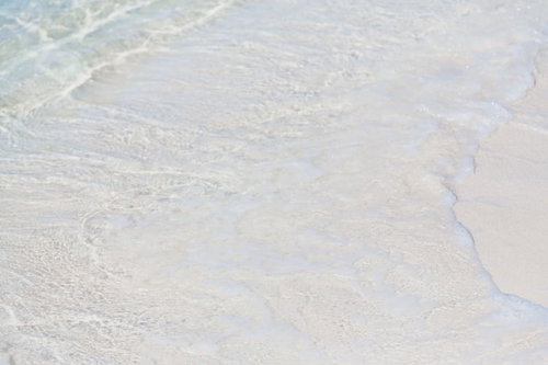 押し寄せる波が砂浜に打ち寄せる瞬間の波打ち際