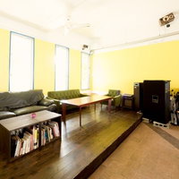 革のソファと木製テーブルが並ぶコワーキングスペースの室内の写真