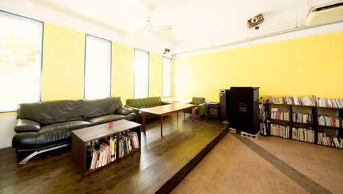 革のソファと木製テーブルが並ぶコワーキングスペースの室内