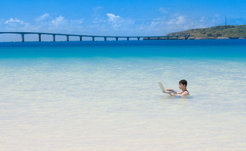 来間島をバックに、海水浴中も即座にメールの返信をする意識高いIT戦士
