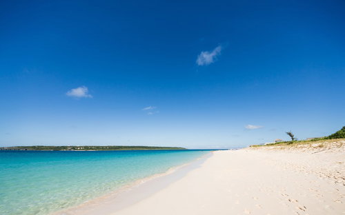 白い砂浜とエメラルドグリーンの透明な海が広がる海岸