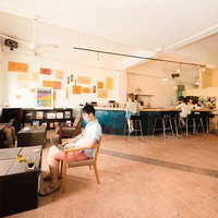 ソファやテーブルに座る複数の人がいるコワーキングスペース全景の写真