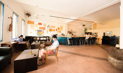 ソファやテーブルに座る複数の人がいるコワーキングスペース全景