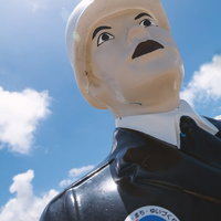 下から見上げた白い肌と黒い服の宮古まもる君の像の写真
