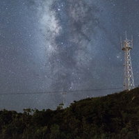 宮古島の夜景に映える鉄塔と天の川、満天の星空の写真