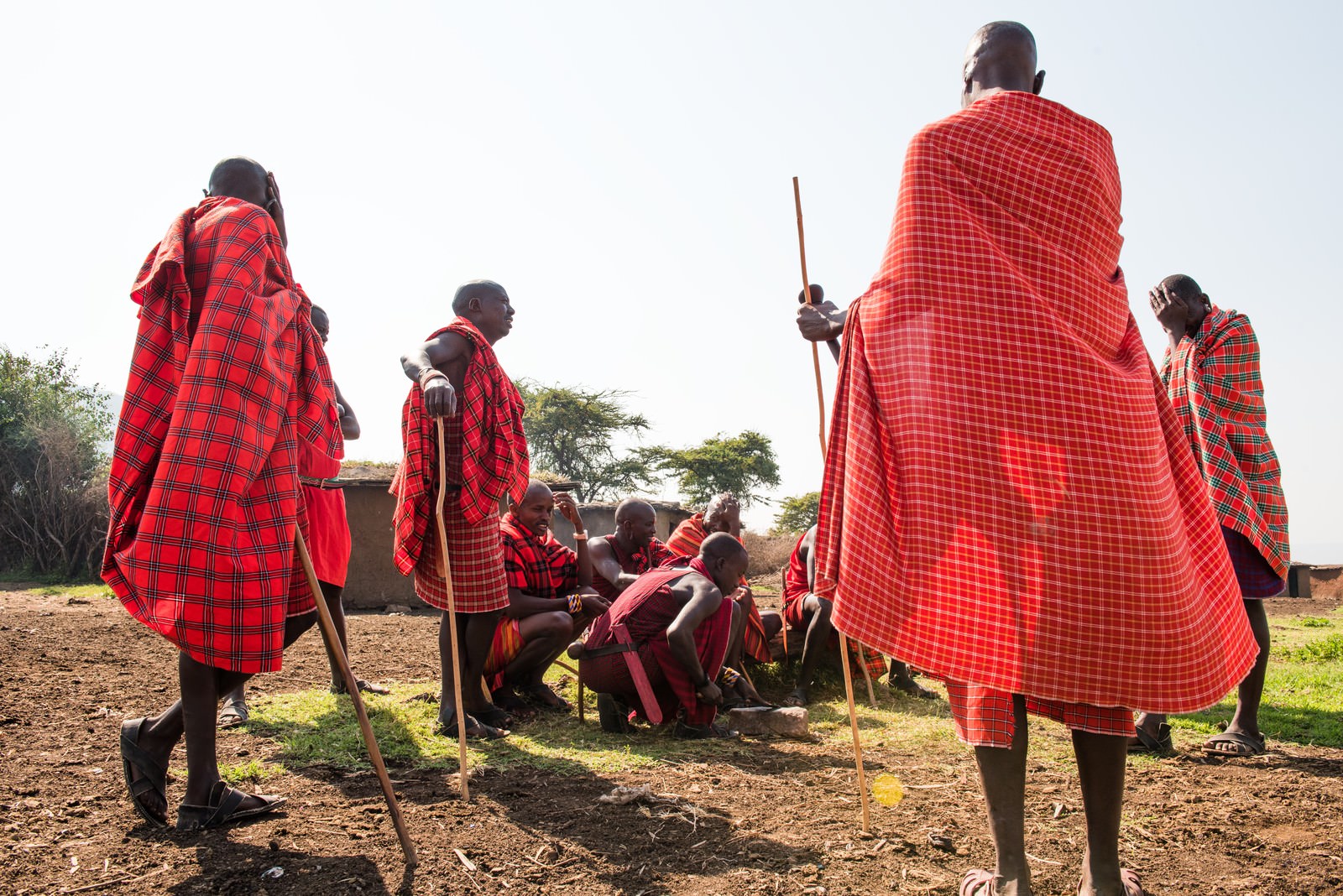 赤いチェック柄の衣装を着たマサイ族が屋外で会議をしている