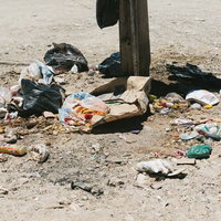 ウユニ市の砂地に散乱したポイ捨てゴミと食べ残しの写真