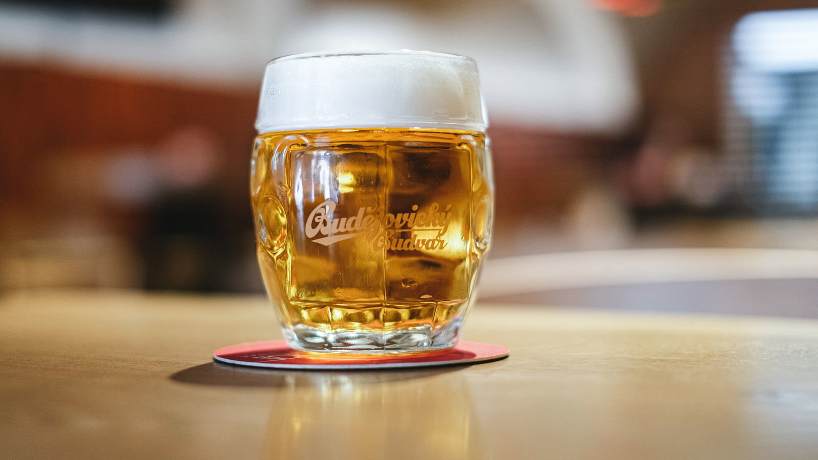 透明なグラスに注がれた琥珀色のビールと白い泡