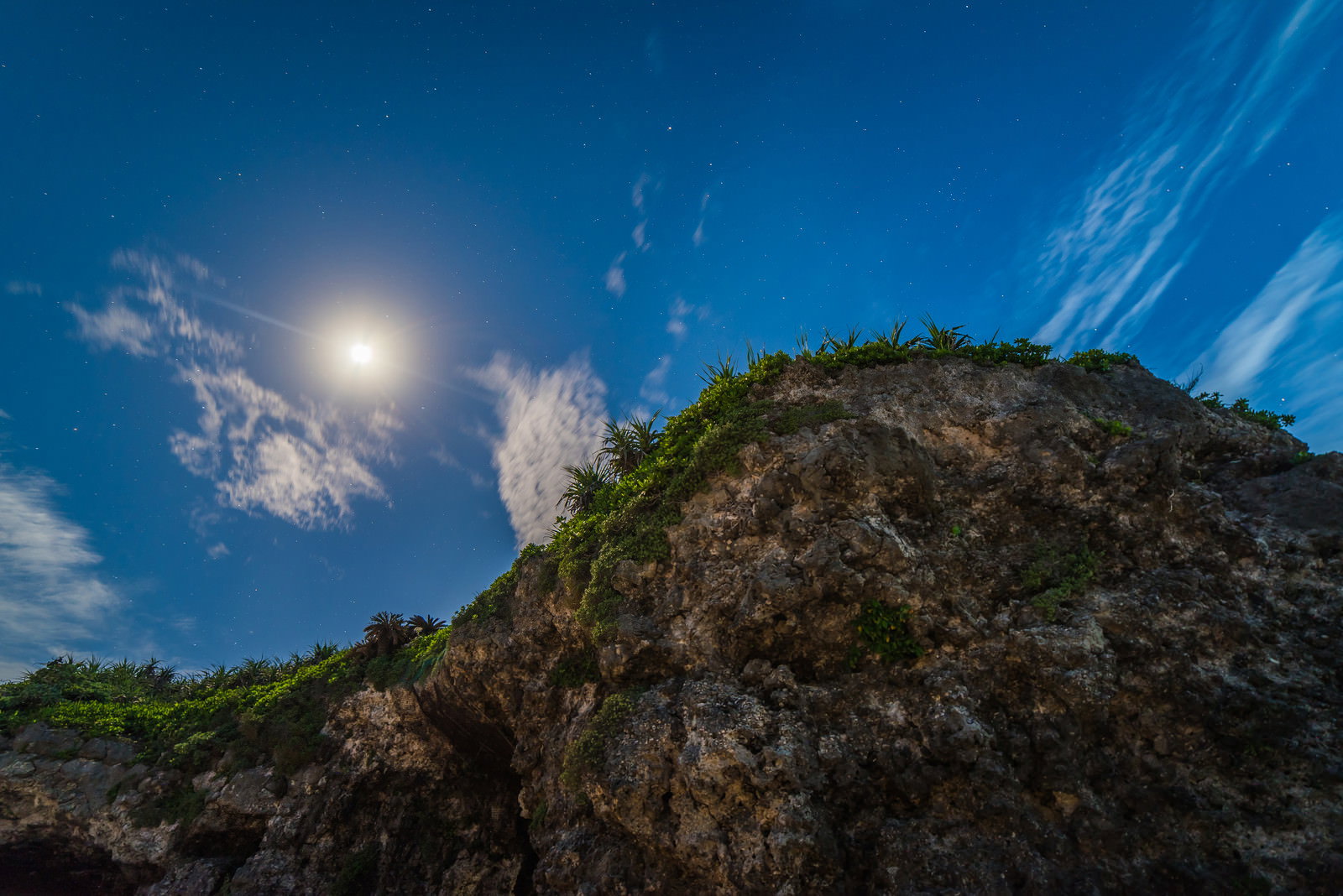 夜空に満月が輝く砂山ビーチの岩の風景