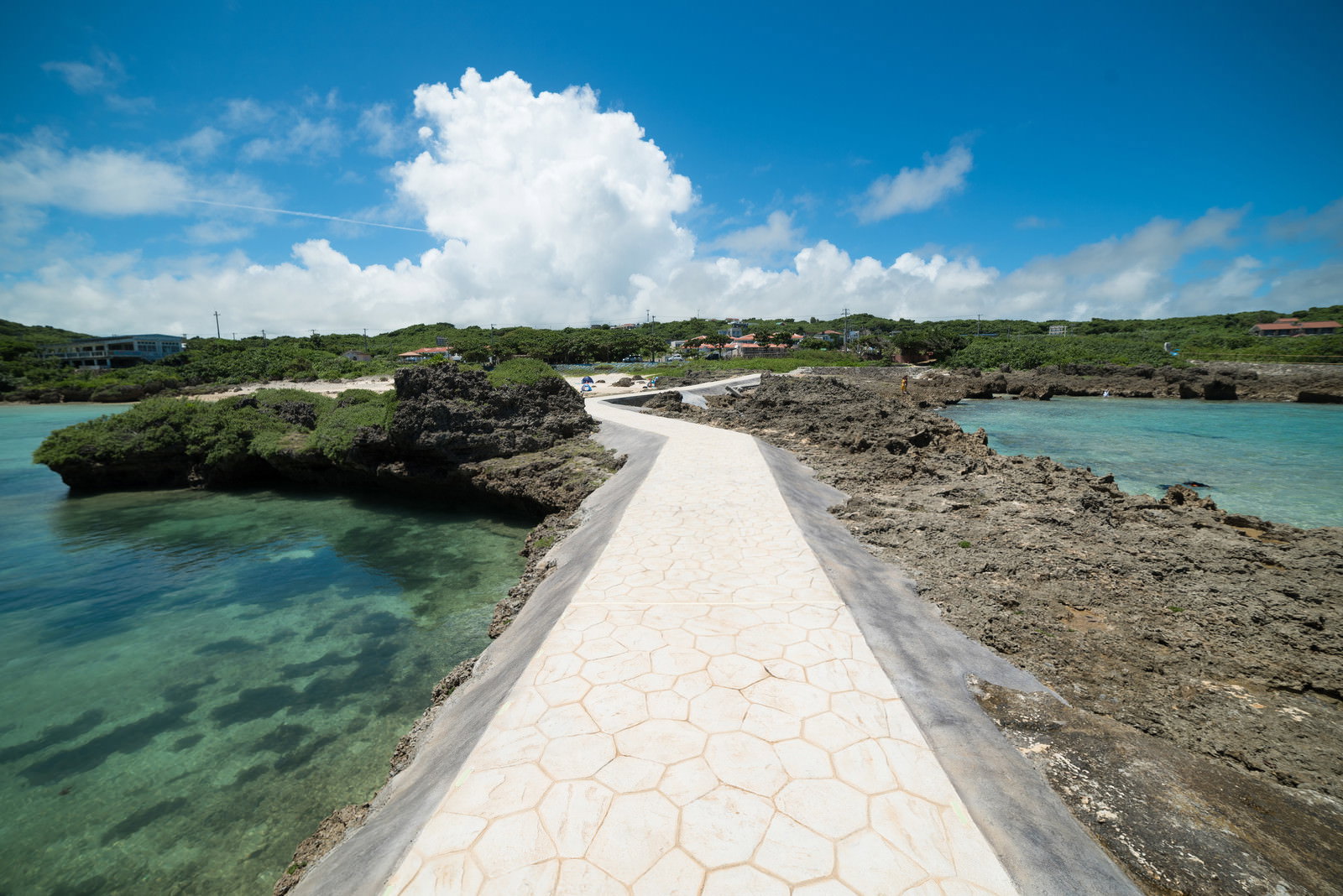 エメラルドグリーンの海に白い桟橋が一直線に伸びる島への一本道