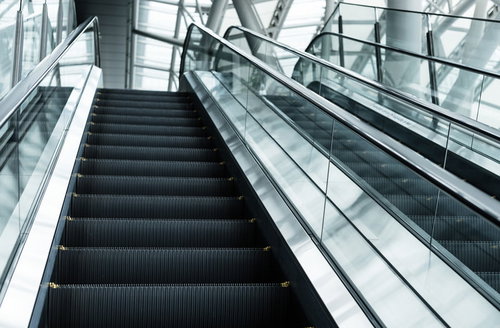 現代的な建物内に並ぶ上りと下りのエスカレーター