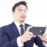 スマートフォンのゲームでミスして脳天直撃を受ける男性の写真