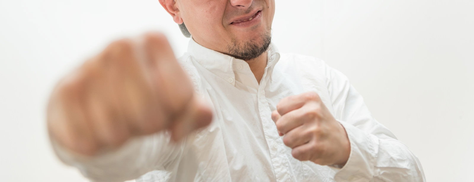 白いシャツの男性が両拳を前に突き出すポーズ