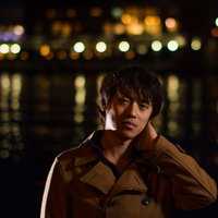 夜景を背景に首の痛みを感じる男性の記念撮影の写真