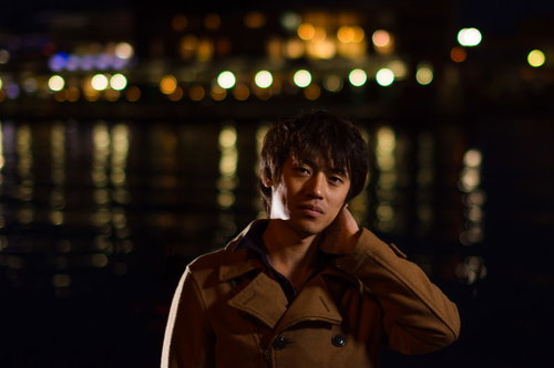 夜景を背景に首の痛みを感じる男性の記念撮影