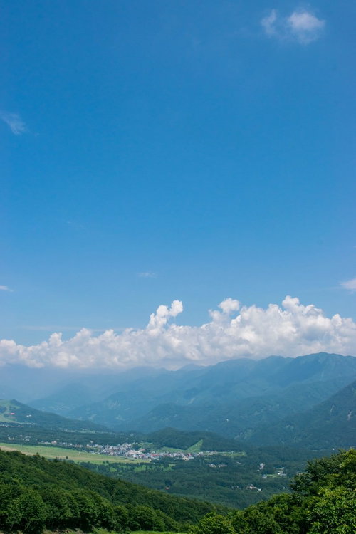 どこまでも続く青い空と霞ゆく山々と麓の町並み
